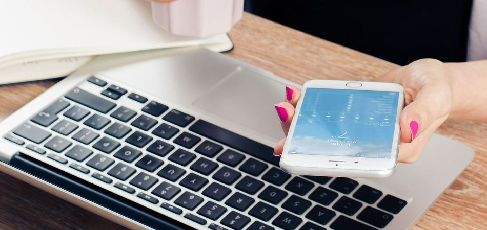 person holding smartphone over keyboard.jpg